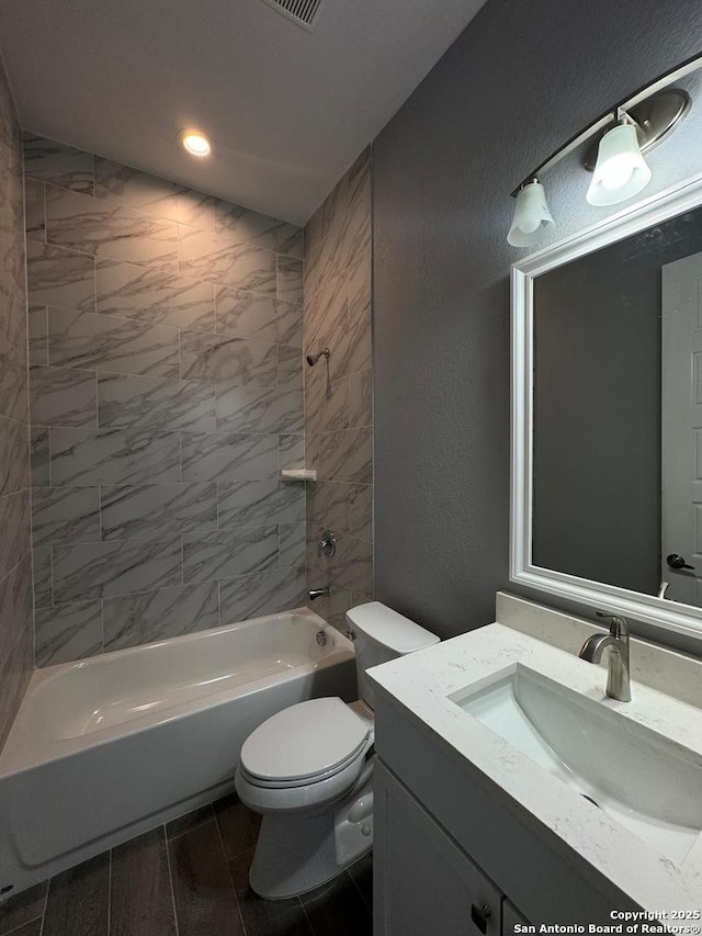 full bathroom featuring vanity, toilet, and tiled shower / bath