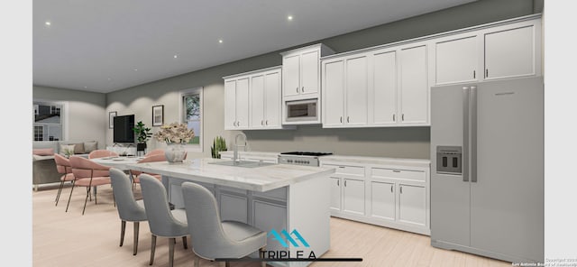 kitchen featuring sink, appliances with stainless steel finishes, white cabinetry, a center island with sink, and light wood-type flooring