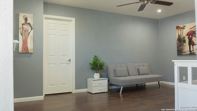 living area featuring dark hardwood / wood-style floors and ceiling fan