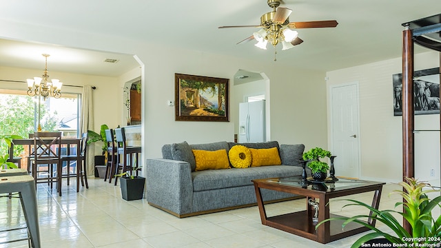 living room featuring ceiling fan with notable chandelier and light tile patterned floors