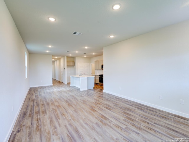 9918 Forestier Grn, San Antonio, TX 78221 - unfurnished living room with recessed lighting, baseboards, light wood-style flooring, and a sink