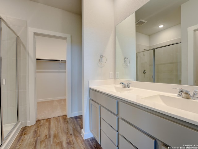 9918 Forestier Grn, San Antonio, TX 78221 - bathroom featuring a shower stall, a spacious closet, double vanity, and wood finished floors
