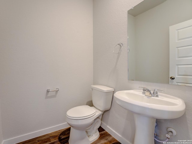 9918 Forestier Grn, San Antonio, TX 78221 - half bath featuring wood finished floors, toilet, and baseboards