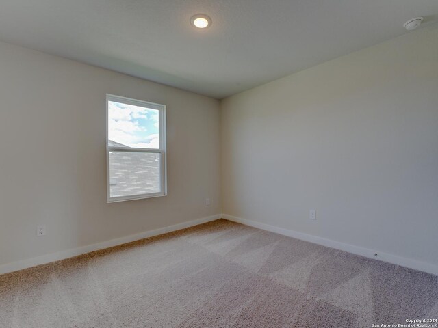 9918 Forestier Grn, San Antonio, TX 78221 - spare room with light carpet, baseboards, and a smoke detector