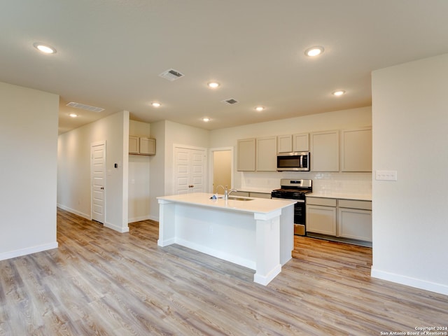 9918 Forestier Grn, San Antonio, TX 78221 - kitchen with appliances with stainless steel finishes, a sink, baseboards, light wood-style floors, and recessed lighting