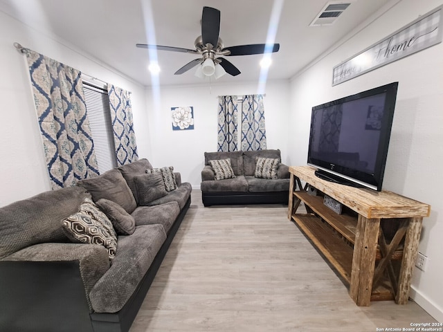 living room with light wood-type flooring, ornamental molding, and ceiling fan