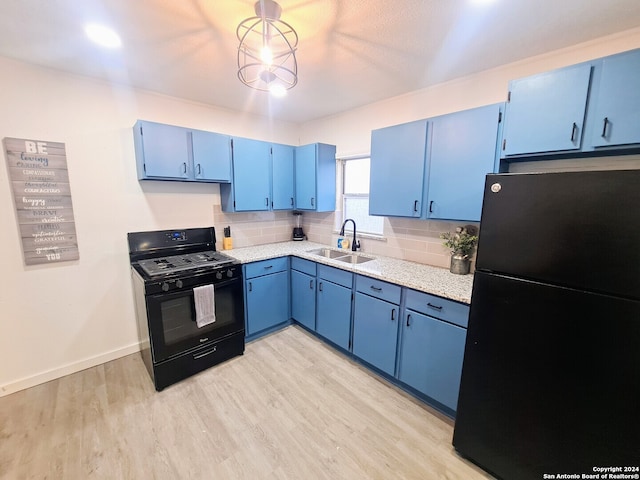 kitchen with decorative backsplash, blue cabinetry, light wood-type flooring, black appliances, and sink