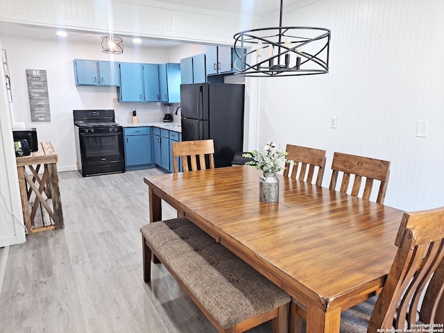 dining room with light hardwood / wood-style flooring and a chandelier