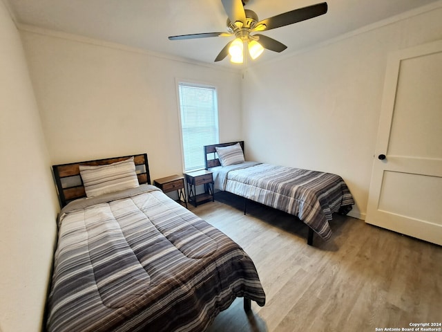 bedroom featuring crown molding, ceiling fan, and light hardwood / wood-style flooring