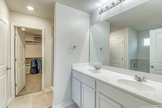 bathroom featuring a textured ceiling, vanity, and tile patterned floors