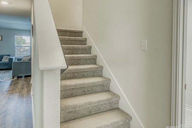 stairs featuring hardwood / wood-style floors