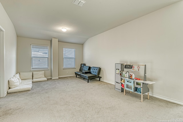 sitting room featuring carpet floors and vaulted ceiling