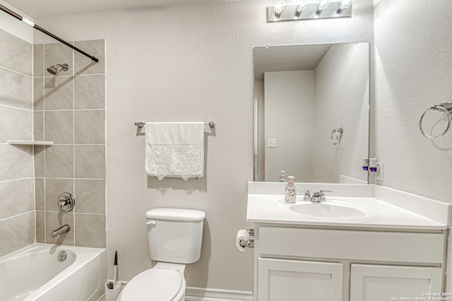 full bathroom featuring tiled shower / bath, vanity, and toilet