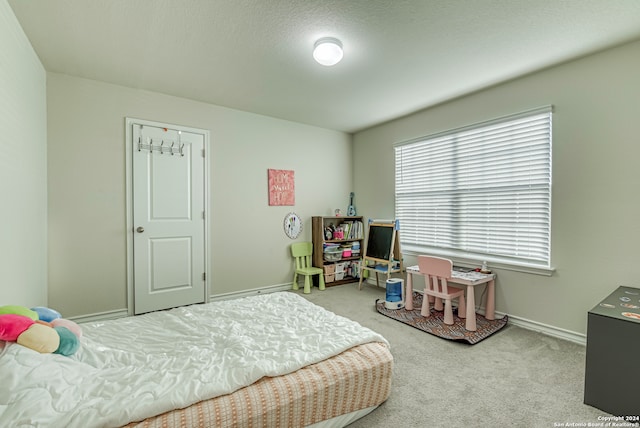 bedroom featuring light carpet and a textured ceiling