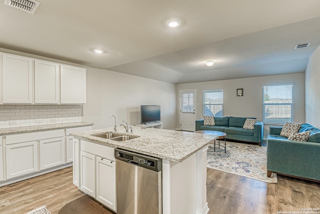 kitchen featuring decorative backsplash, white cabinets, light wood-type flooring, stainless steel dishwasher, and sink