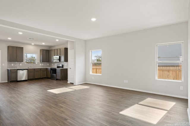 kitchen with backsplash, light hardwood / wood-style floors, and stainless steel appliances