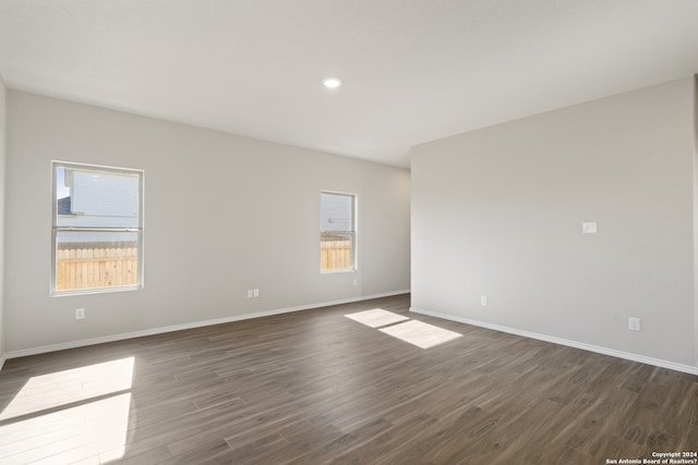 spare room with dark hardwood / wood-style floors and a healthy amount of sunlight