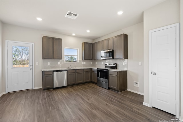 kitchen featuring backsplash, appliances with stainless steel finishes, dark hardwood / wood-style floors, and sink