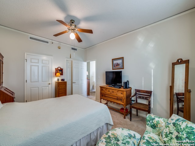 bedroom featuring light carpet, ceiling fan, and a textured ceiling