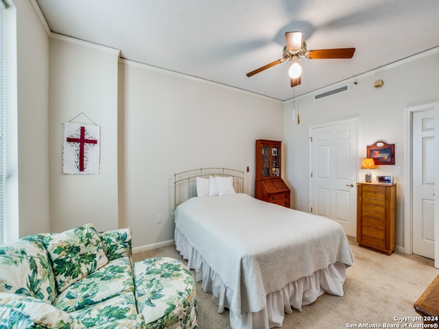 bedroom featuring ceiling fan, light colored carpet, and crown molding