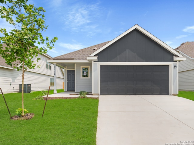 view of front facade with a garage, central AC unit, and a front yard