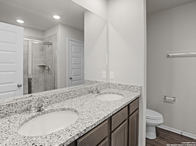 bathroom featuring hardwood / wood-style flooring, vanity, toilet, and an enclosed shower