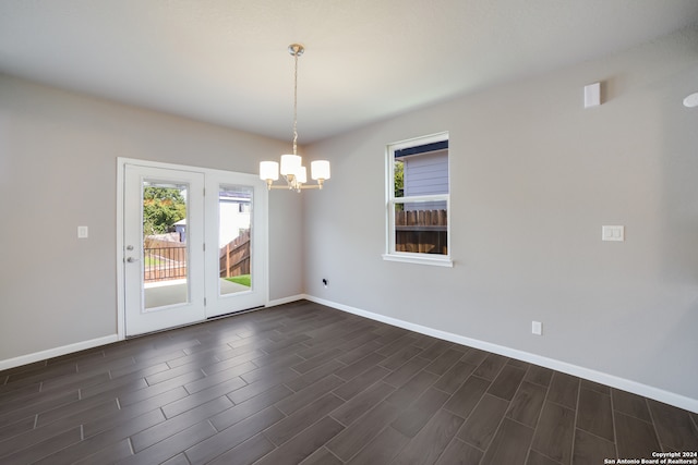 unfurnished room with dark wood-type flooring and a notable chandelier