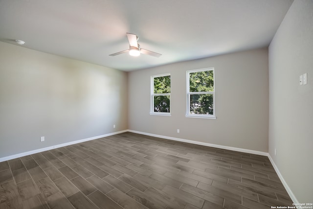 spare room with ceiling fan and dark wood-type flooring