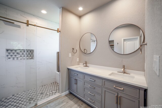 bathroom with vanity and a shower with door