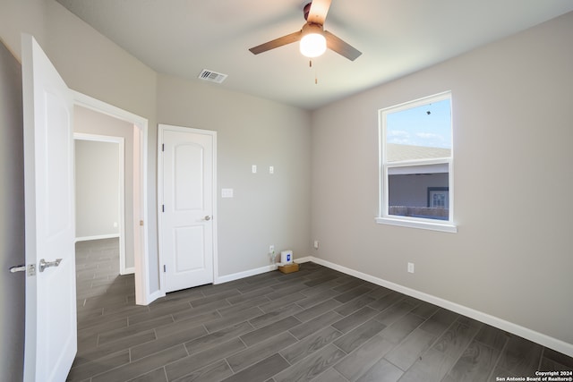 spare room featuring ceiling fan and dark wood-type flooring