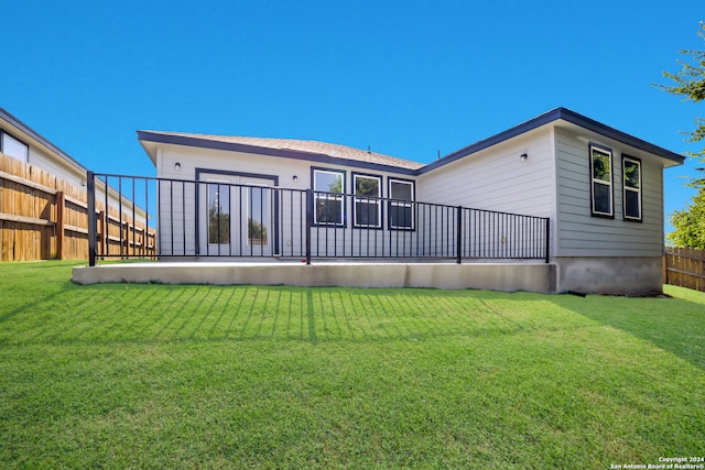 rear view of house featuring a yard