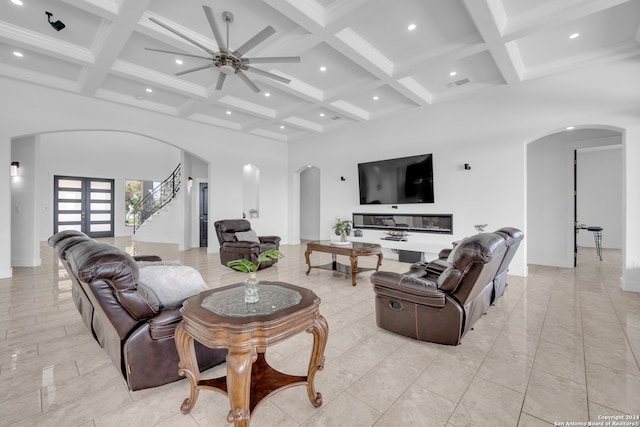 living room with coffered ceiling, light tile patterned floors, beam ceiling, and ceiling fan