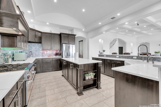 kitchen with dark brown cabinetry, stainless steel appliances, sink, and a kitchen island