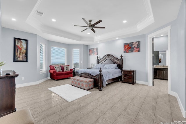 bedroom featuring ceiling fan, a raised ceiling, connected bathroom, and ornamental molding