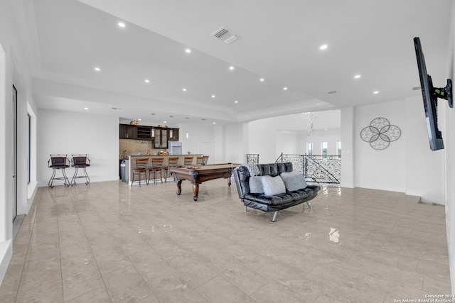 living room with billiards, a raised ceiling, ornamental molding, and indoor bar