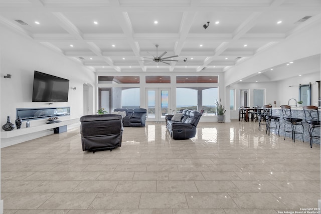 living room with ceiling fan, beamed ceiling, crown molding, and coffered ceiling