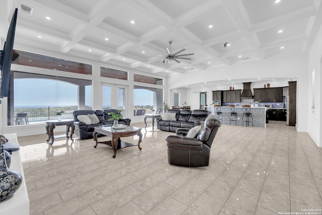 living room with ceiling fan, plenty of natural light, beam ceiling, and coffered ceiling