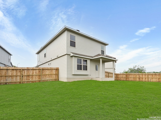 back of house with a lawn