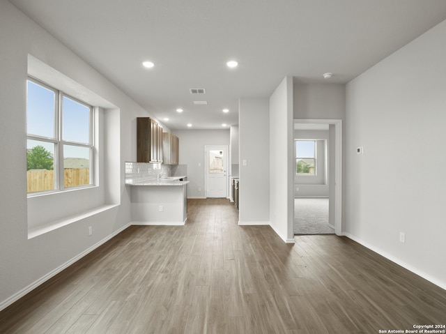 unfurnished living room featuring dark wood-type flooring and a healthy amount of sunlight