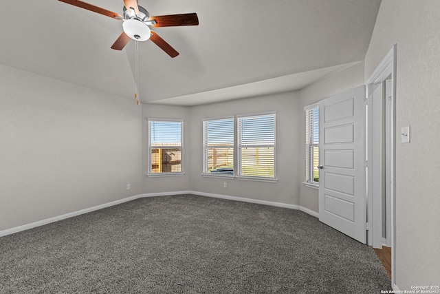 spare room featuring dark carpet, ceiling fan, and lofted ceiling