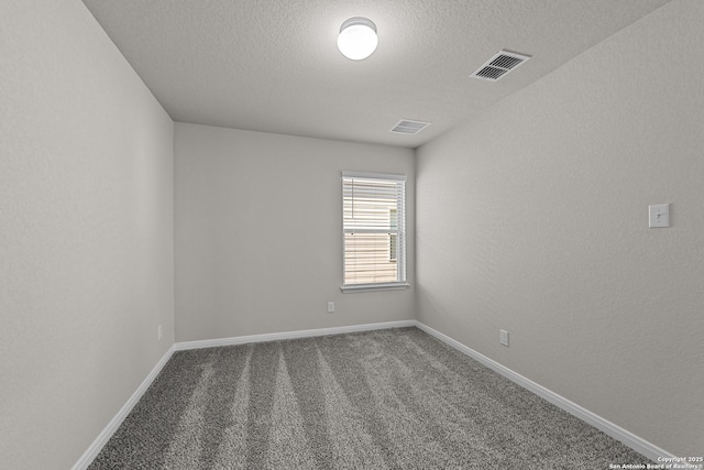 empty room with carpet and a textured ceiling