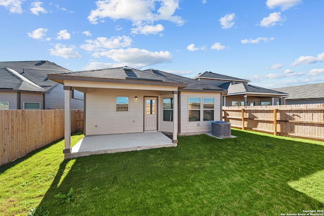 rear view of house with cooling unit, a yard, and a patio