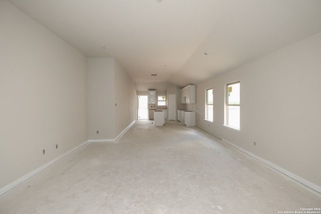 unfurnished living room featuring vaulted ceiling