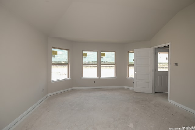 unfurnished room with vaulted ceiling and a healthy amount of sunlight