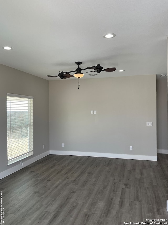 unfurnished room with ceiling fan and dark wood-type flooring