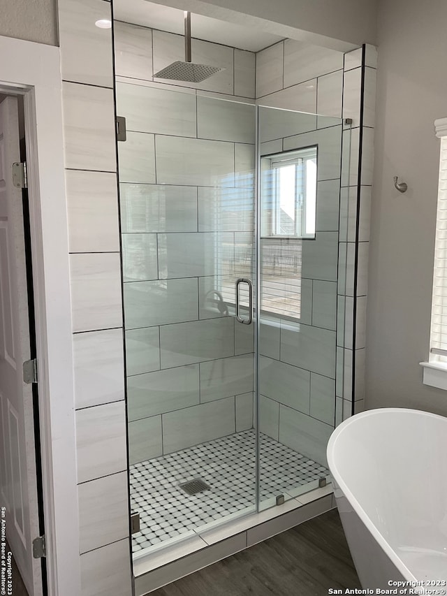 bathroom featuring shower with separate bathtub and hardwood / wood-style floors