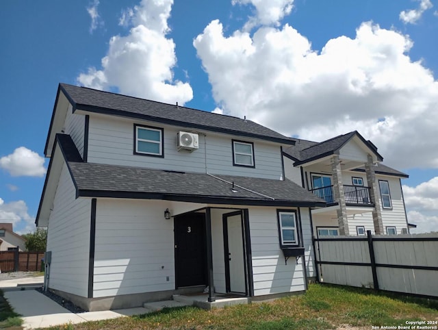 exterior space with a balcony and an AC wall unit