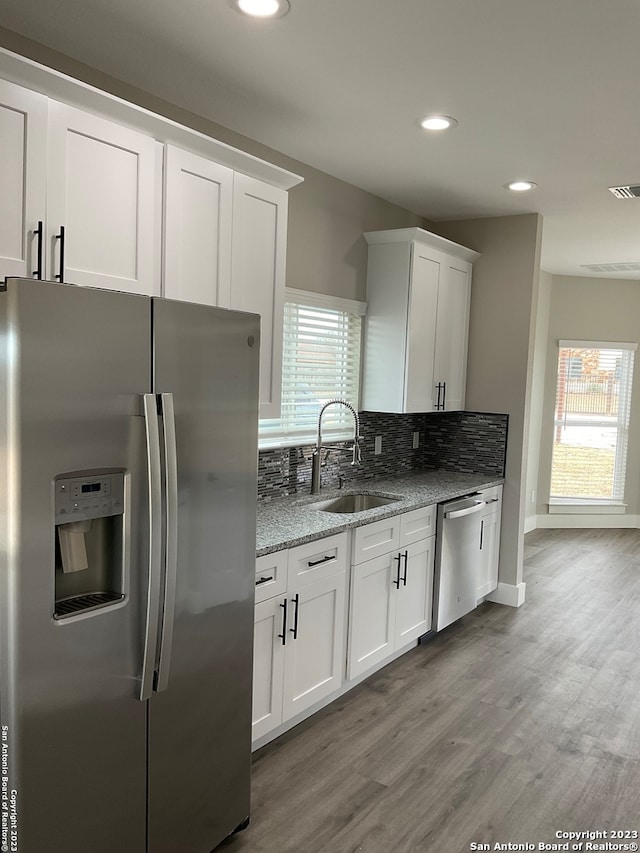 kitchen featuring white cabinets, stainless steel appliances, sink, and a healthy amount of sunlight