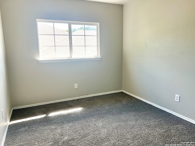 empty room featuring dark carpet