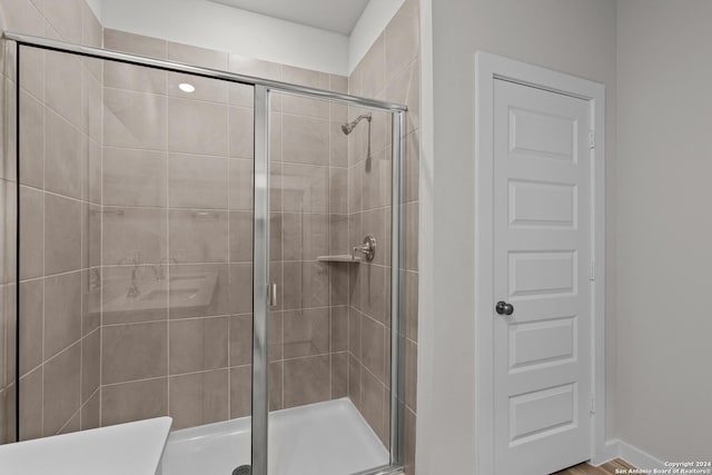 bathroom featuring a shower with door